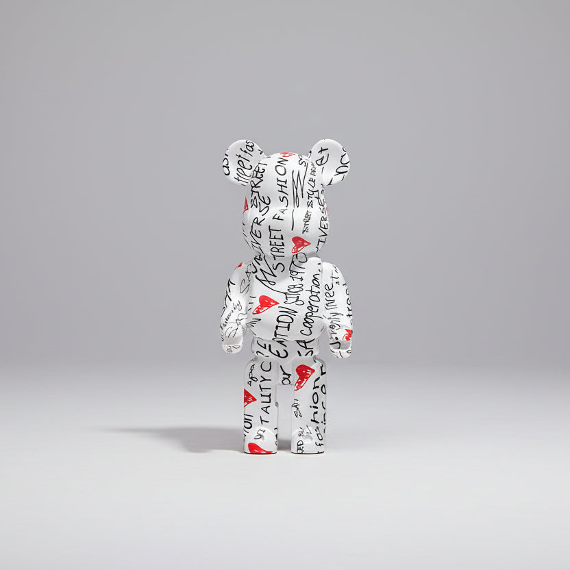 Decorative bear figure with text pattern on a wooden surface, with measurements displayed.